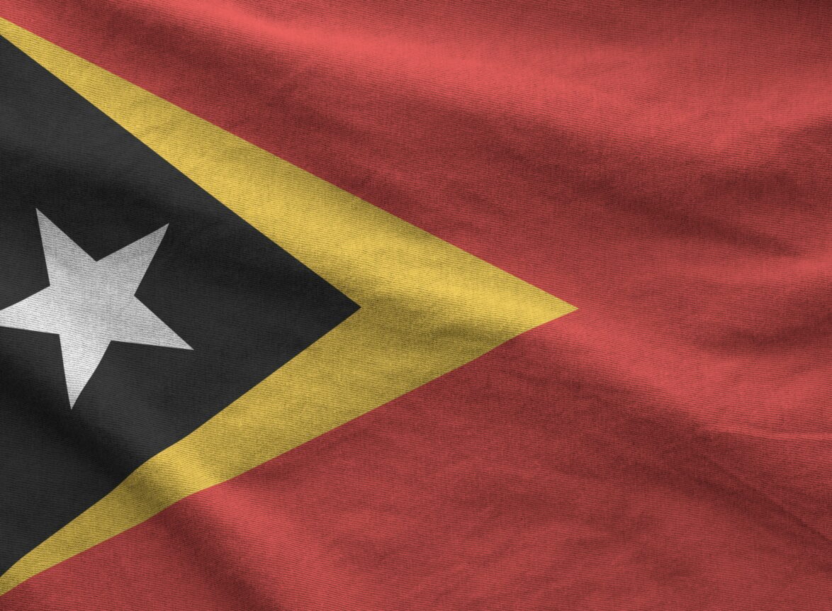 Timor Leste flag depicted on folded wavy fabric of old cloth